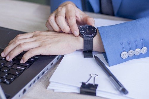 darbuotojas tikrina laikrodį